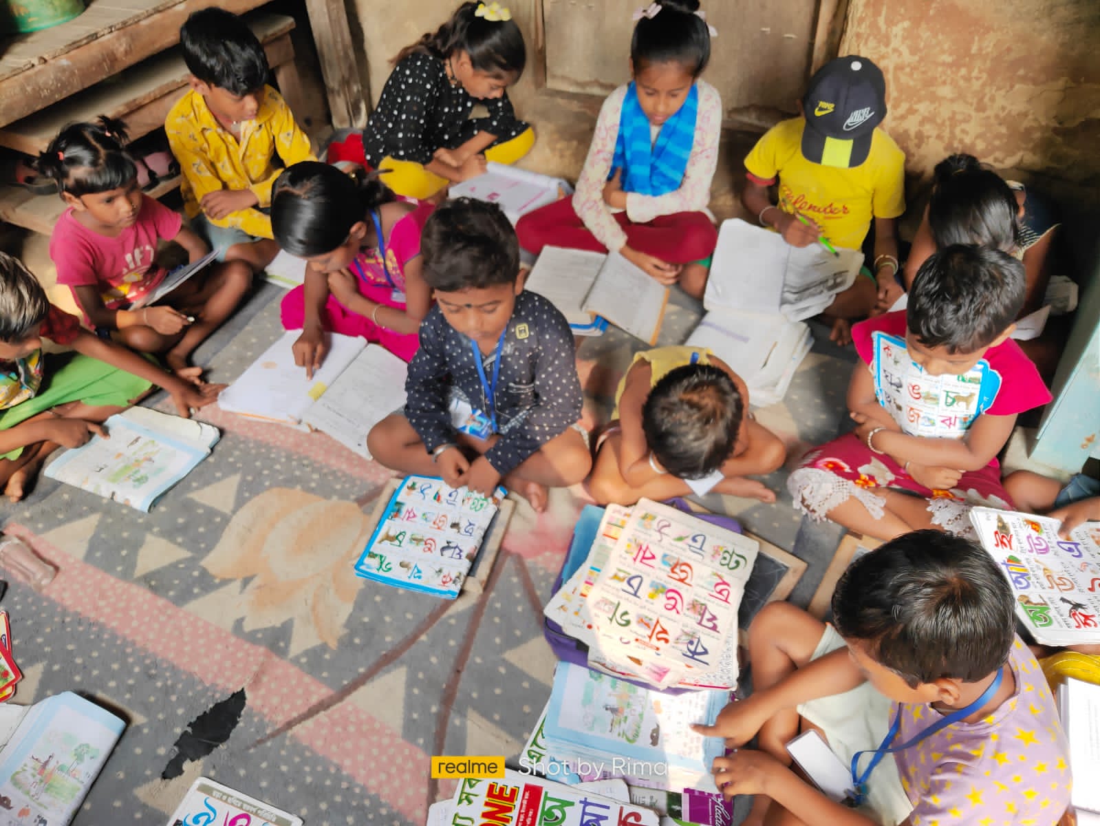 Children reading Bengali alphabet books together